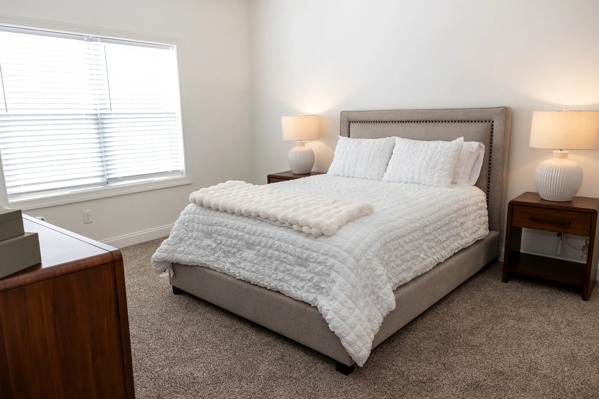 The Cottages master bedroom with upholstered bed